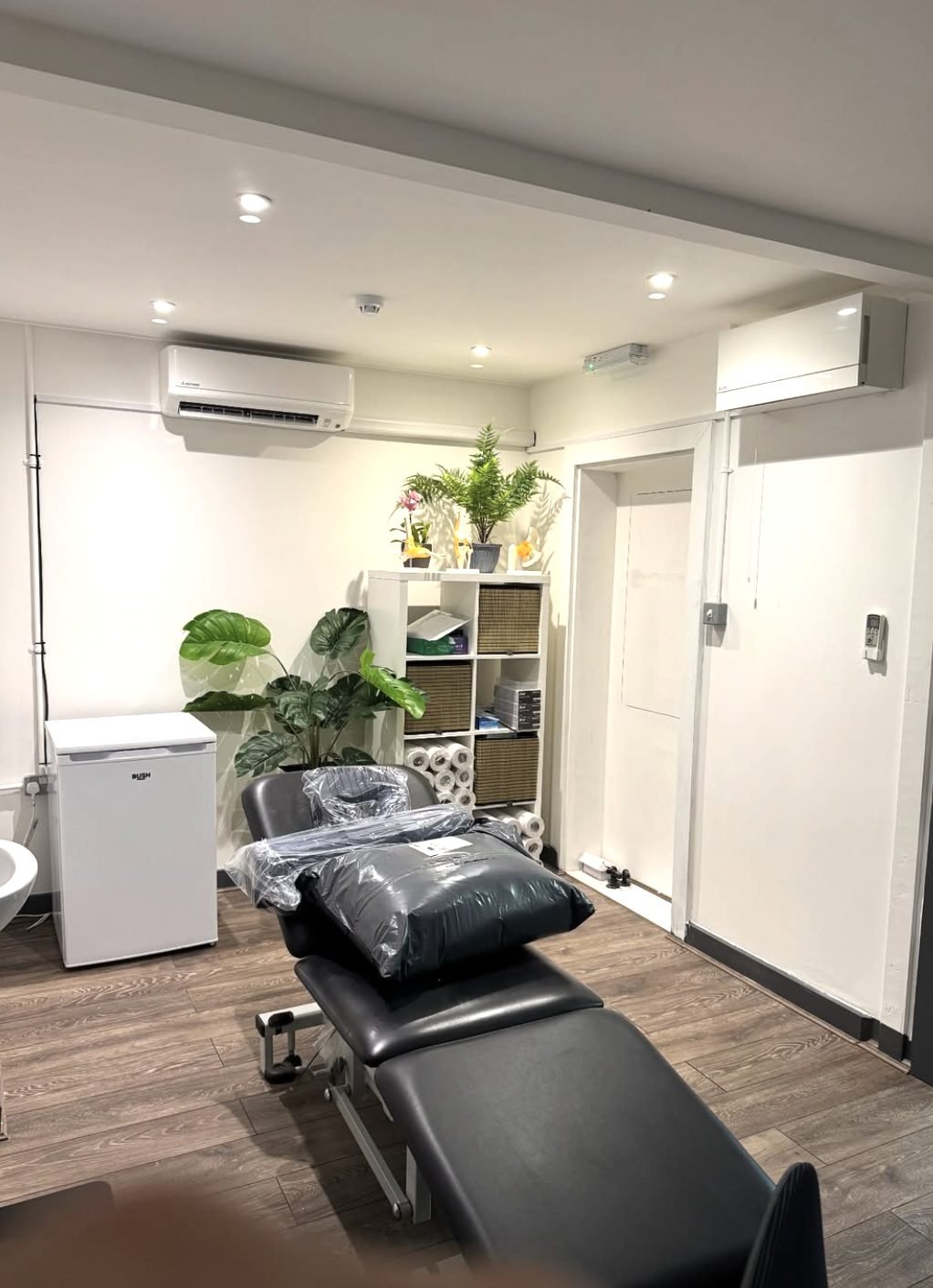 Two wall-mounted indoor air conditioning units installed in a treatment room